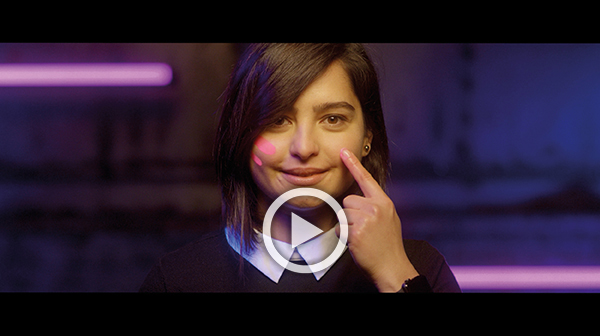 A screenshot of the Rare Disease Day 2018 video that shows a girl painting pink stripes onto her cheek.