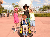 A woman with her three children raising their hands in recognition of rare disease day 2015.