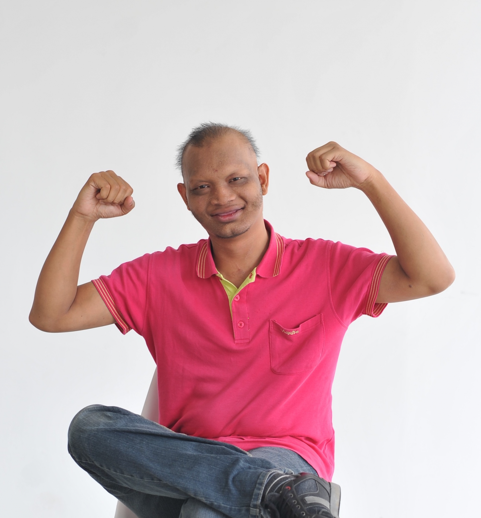 Image of Syafiq holding his arms up to show his strength