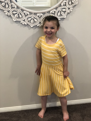Angelina wearing a yellow dress smiling.