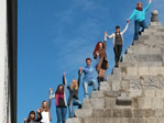 People holding hands and standing on different steps.