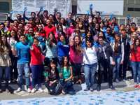 An image of a group of people raising their hands with painted palms to recognise rare disease day.